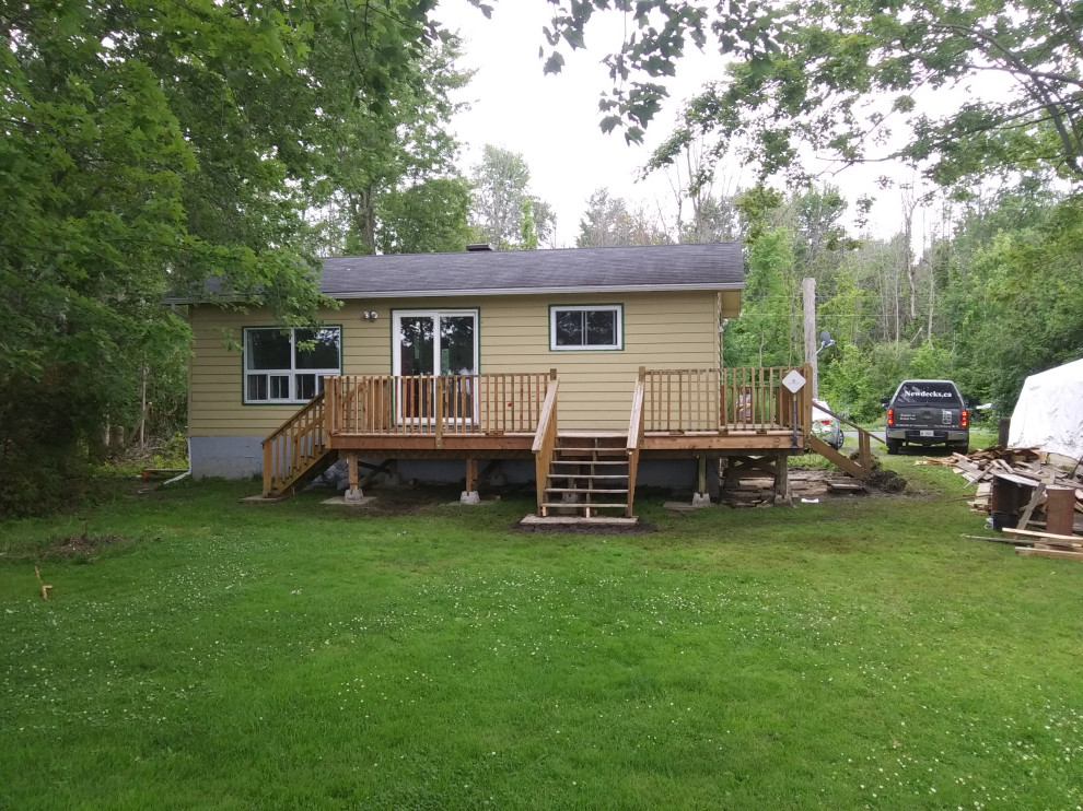 Large transitional backyard wood railing deck photo in Ottawa