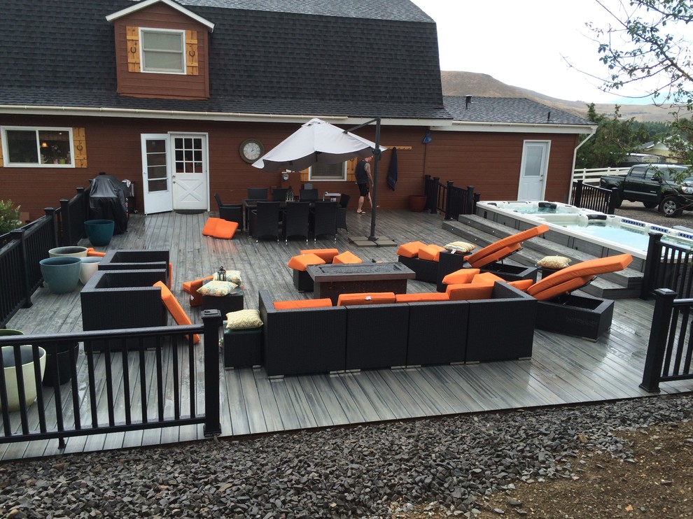 Example of a mid-sized mountain style backyard deck design with no cover