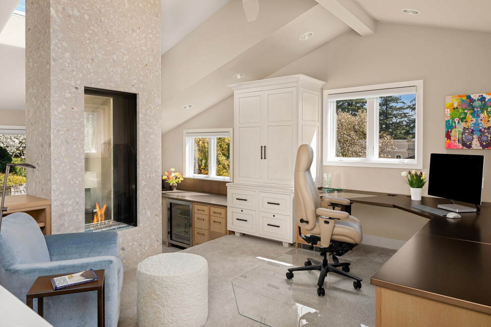 Cette photo montre un bureau de taille moyenne avec un mur beige, moquette, une cheminée double-face, un manteau de cheminée en carrelage, un sol beige et un plafond voûté.