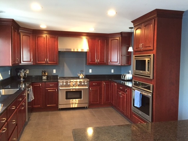 Large traditional u-shaped separate kitchen in Boston with an undermount sink, raised-panel cabinets, red cabinets, quartz benchtops, blue splashback, stainless steel appliances, porcelain floors and with island.