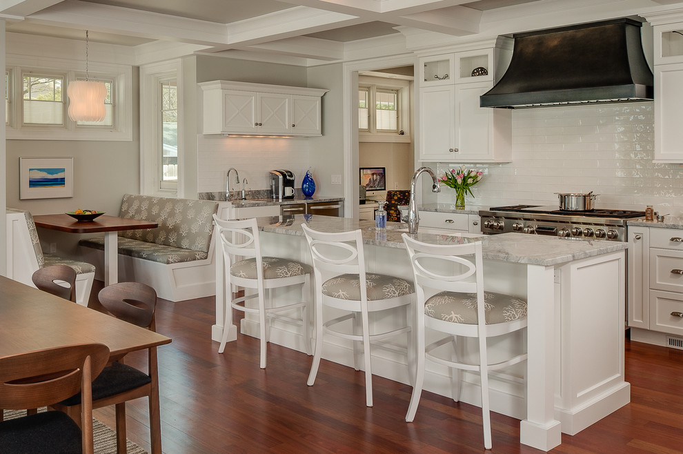 Inspiration for a large transitional single-wall medium tone wood floor eat-in kitchen remodel with an undermount sink, recessed-panel cabinets, white cabinets, marble countertops, white backsplash, ceramic backsplash, stainless steel appliances and an island