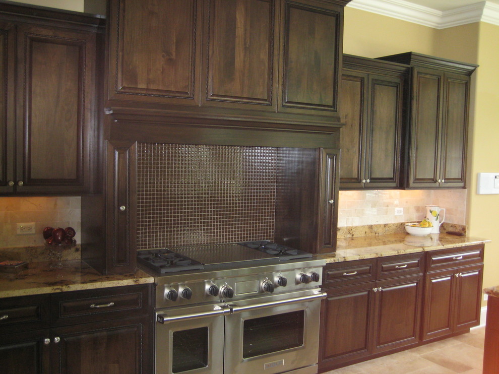 Mid-sized transitional l-shaped ceramic tile open concept kitchen photo in Chicago with an island, raised-panel cabinets, dark wood cabinets, beige backsplash, subway tile backsplash and stainless steel appliances