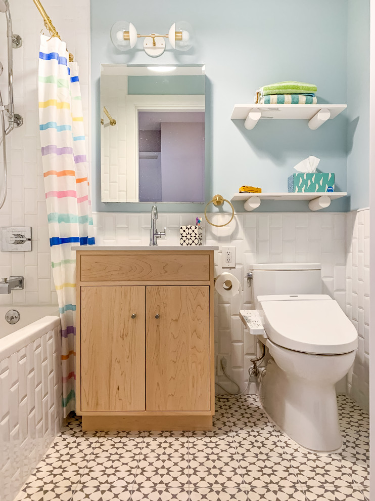 Inspiration for a transitional bathroom in New York with flat-panel cabinets, light wood cabinets, an alcove tub, a shower/bathtub combo, white tile, subway tile, blue walls, multi-coloured floor, a shower curtain, yellow benchtops, a single vanity and a built-in vanity.