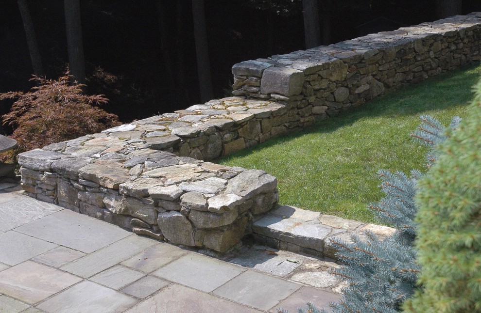Mid-sized country backyard patio in Bridgeport with natural stone pavers and no cover.