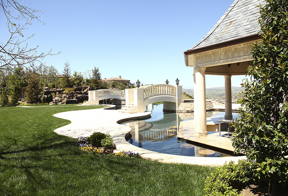 Inspiration for an expansive traditional backyard full sun formal garden in San Francisco with a retaining wall and concrete pavers.