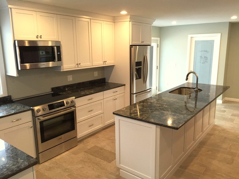 Mid-sized transitional l-shaped travertine floor kitchen photo in Boston with a single-bowl sink, stainless steel appliances, shaker cabinets, white cabinets, marble countertops and an island