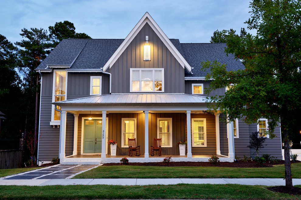 This is an example of a mid-sized transitional three-storey grey house exterior in Raleigh with vinyl siding, a gable roof and a shingle roof.