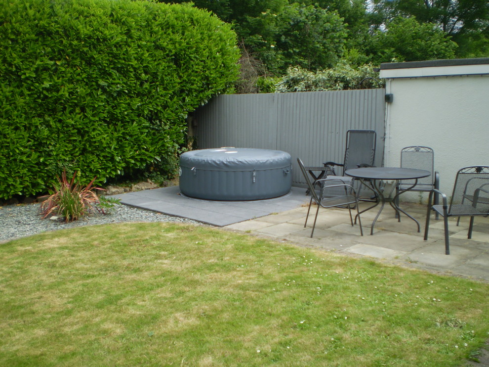 This is an example of a mid-sized contemporary backyard patio in Sussex with concrete pavers.