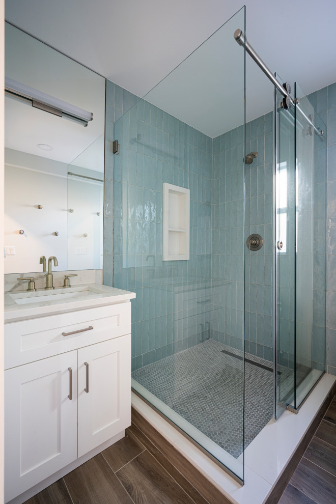 Example of a mid-sized beach style master beige tile and ceramic tile porcelain tile, brown floor and single-sink alcove shower design in Miami with shaker cabinets, white cabinets, a one-piece toilet, white walls, an undermount sink, quartzite countertops, a hinged shower door, white countertops and a built-in vanity