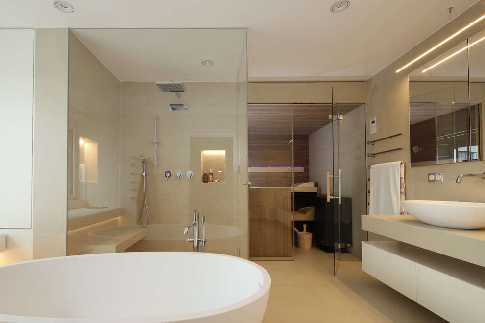 Design ideas for a large contemporary bathroom in Other with flat-panel cabinets, beige cabinets, a freestanding tub, a curbless shower, beige tile, cement tile, beige walls, cement tiles, with a sauna, a vessel sink, concrete benchtops, beige floor and a hinged shower door.