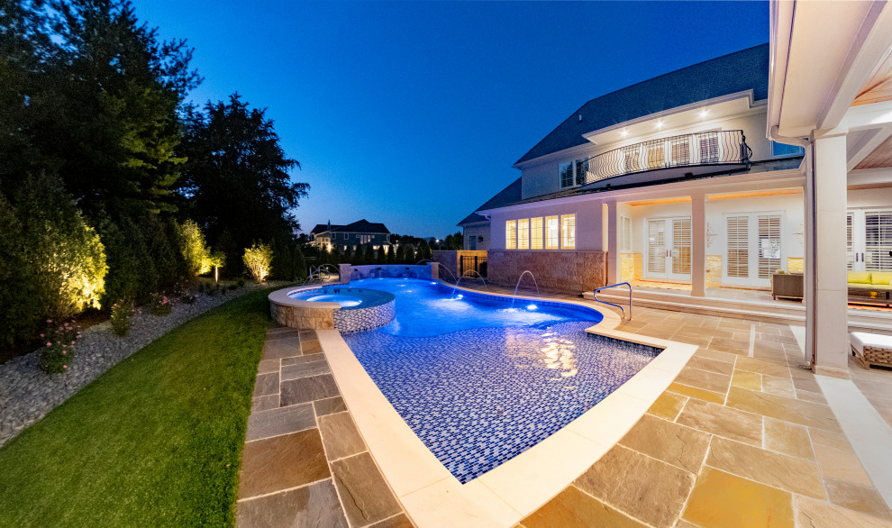Mid-sized modern backyard custom-shaped natural pool in Chicago with with a pool and natural stone pavers.