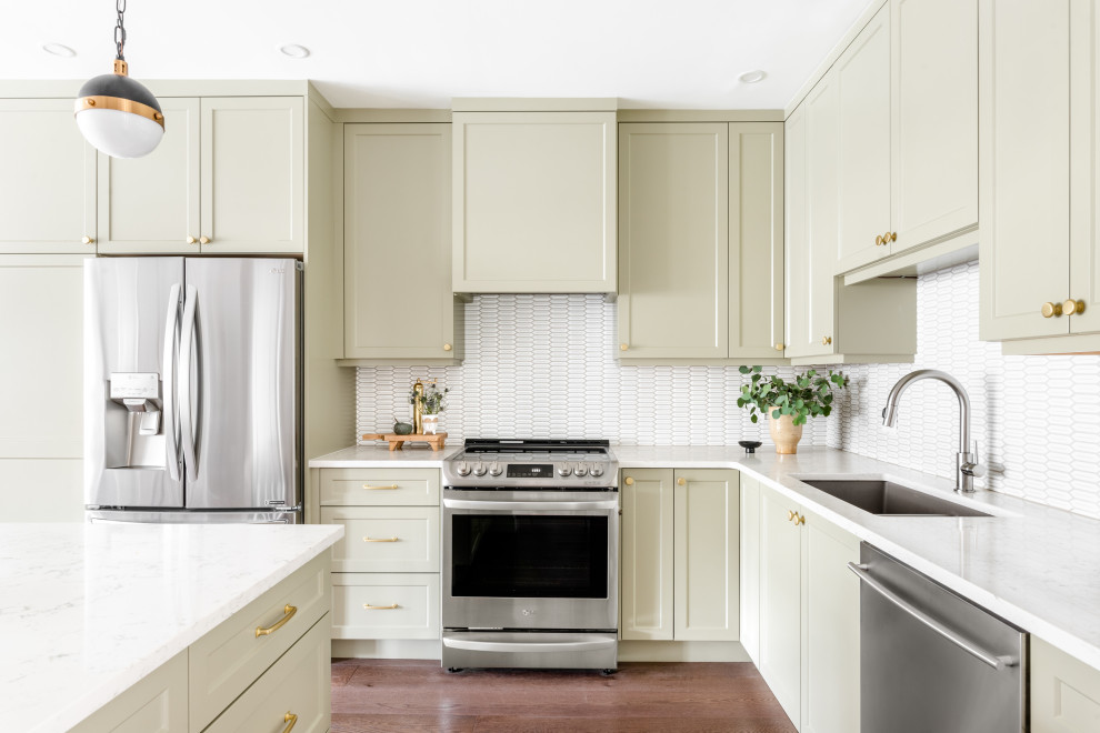 Inspiration for a small transitional brown floor kitchen remodel with shaker cabinets, green cabinets, white backsplash, stainless steel appliances, an island and white countertops
