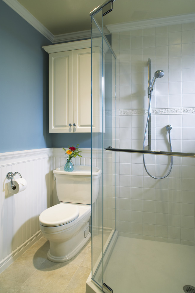 Immagine di una stanza da bagno tradizionale con ante con bugna sagomata, ante bianche, doccia ad angolo, WC a due pezzi e piastrelle bianche