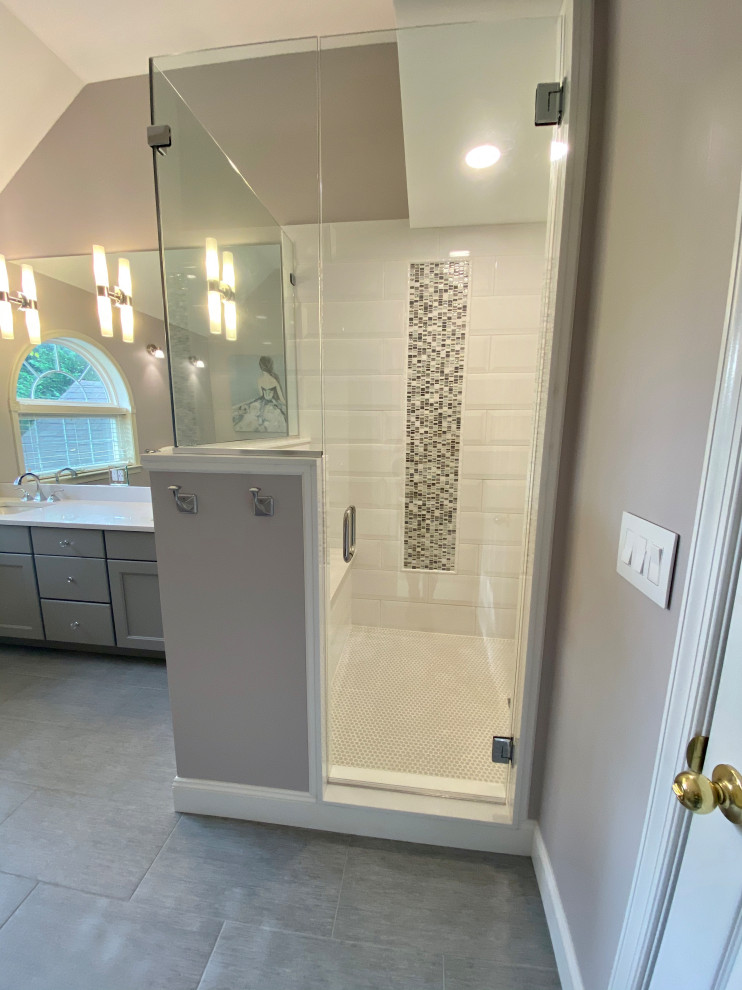 This is an example of a large transitional master bathroom in Philadelphia with flat-panel cabinets, grey cabinets, a freestanding tub, a two-piece toilet, grey walls, ceramic floors, an undermount sink, engineered quartz benchtops, grey floor, white benchtops, a shower seat, a double vanity and a built-in vanity.
