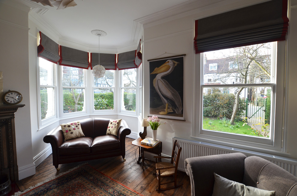 Photo of a medium sized victorian living room in London with beige walls, dark hardwood flooring, a standard fireplace and a metal fireplace surround.