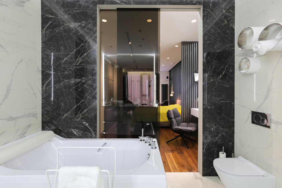 Design ideas for a large contemporary master bathroom in London with raised-panel cabinets, white cabinets, a corner tub, an alcove shower, a one-piece toilet, black and white tile, marble, white walls, marble floors, an integrated sink, laminate benchtops, white floor, an open shower and white benchtops.