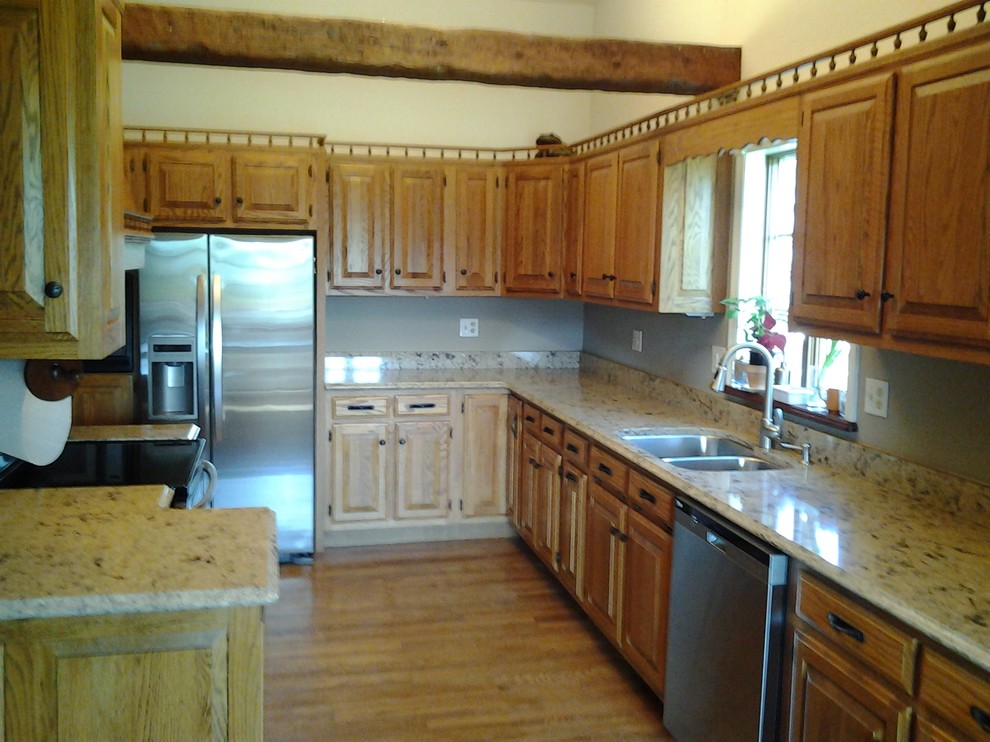 Mid-sized mountain style medium tone wood floor enclosed kitchen photo in Indianapolis with an undermount sink, raised-panel cabinets, medium tone wood cabinets, quartzite countertops, stainless steel appliances and no island