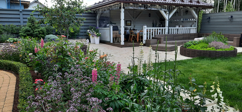 Exemple d'une terrasse chic de taille moyenne avec une cuisine d'été, une cour, une pergola et un garde-corps en bois.