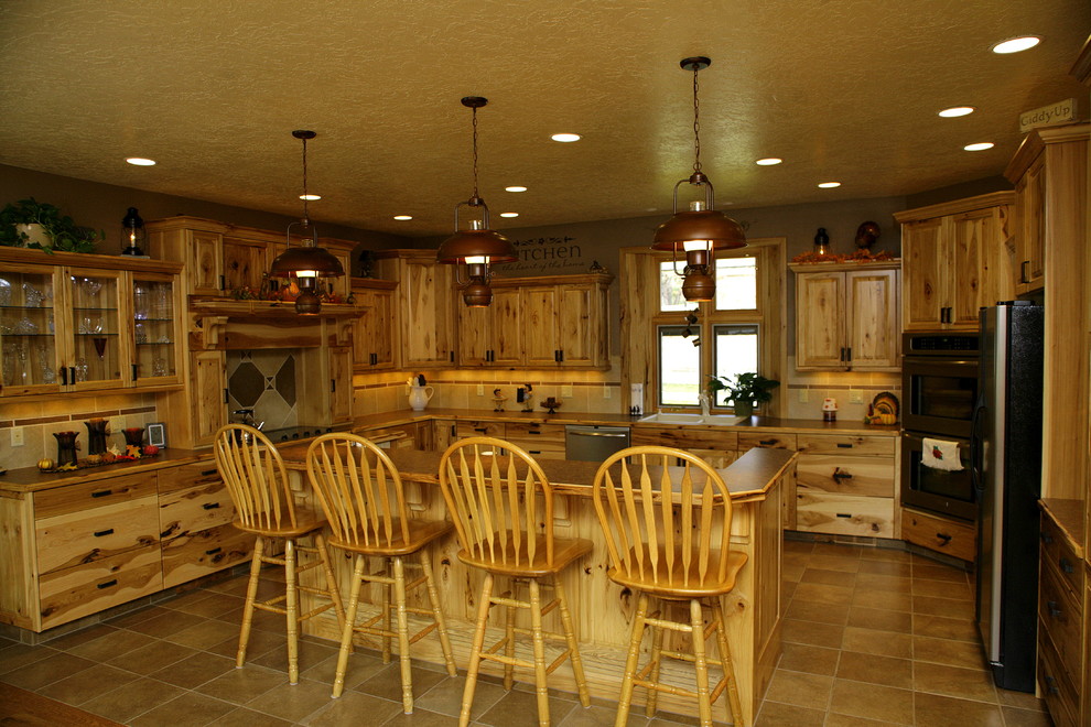 Mid-sized country u-shaped eat-in kitchen in Denver with a double-bowl sink, raised-panel cabinets, light wood cabinets, wood benchtops, beige splashback, ceramic splashback, stainless steel appliances, ceramic floors and with island.