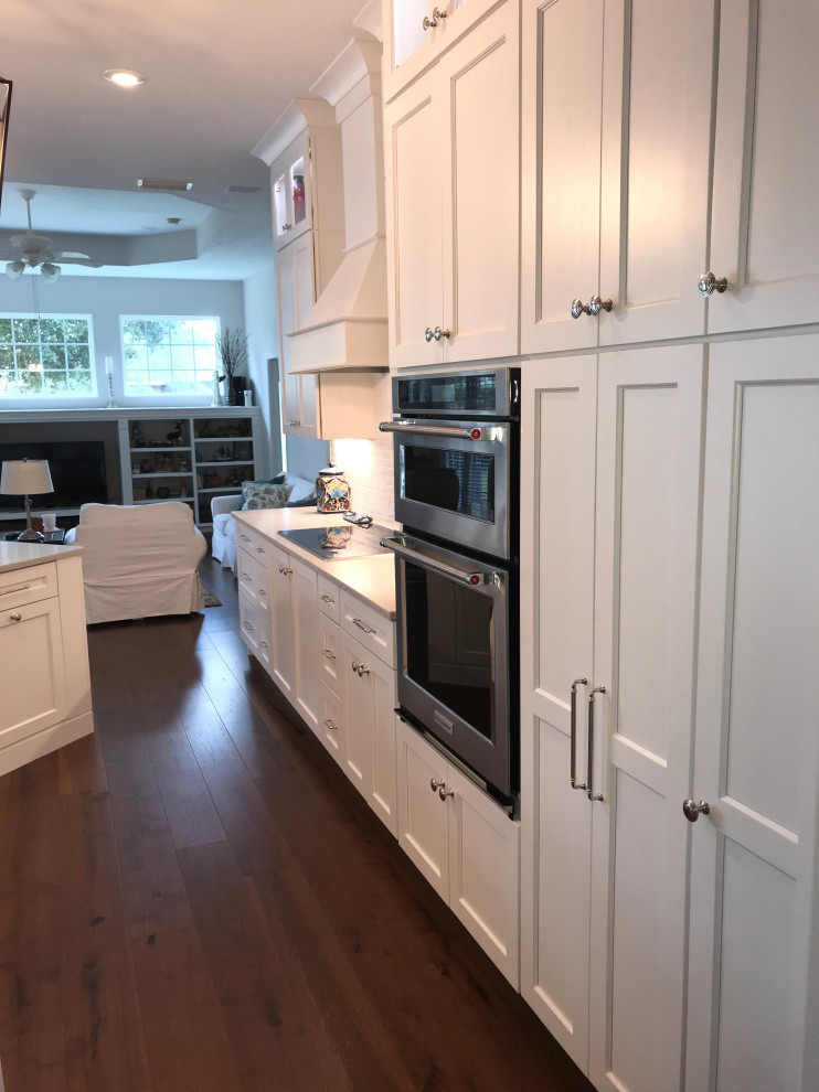 Design ideas for a large modern u-shaped eat-in kitchen in Jacksonville with an undermount sink, shaker cabinets, white cabinets, quartzite benchtops, white splashback, glass tile splashback, stainless steel appliances, dark hardwood floors, with island, brown floor and grey benchtop.