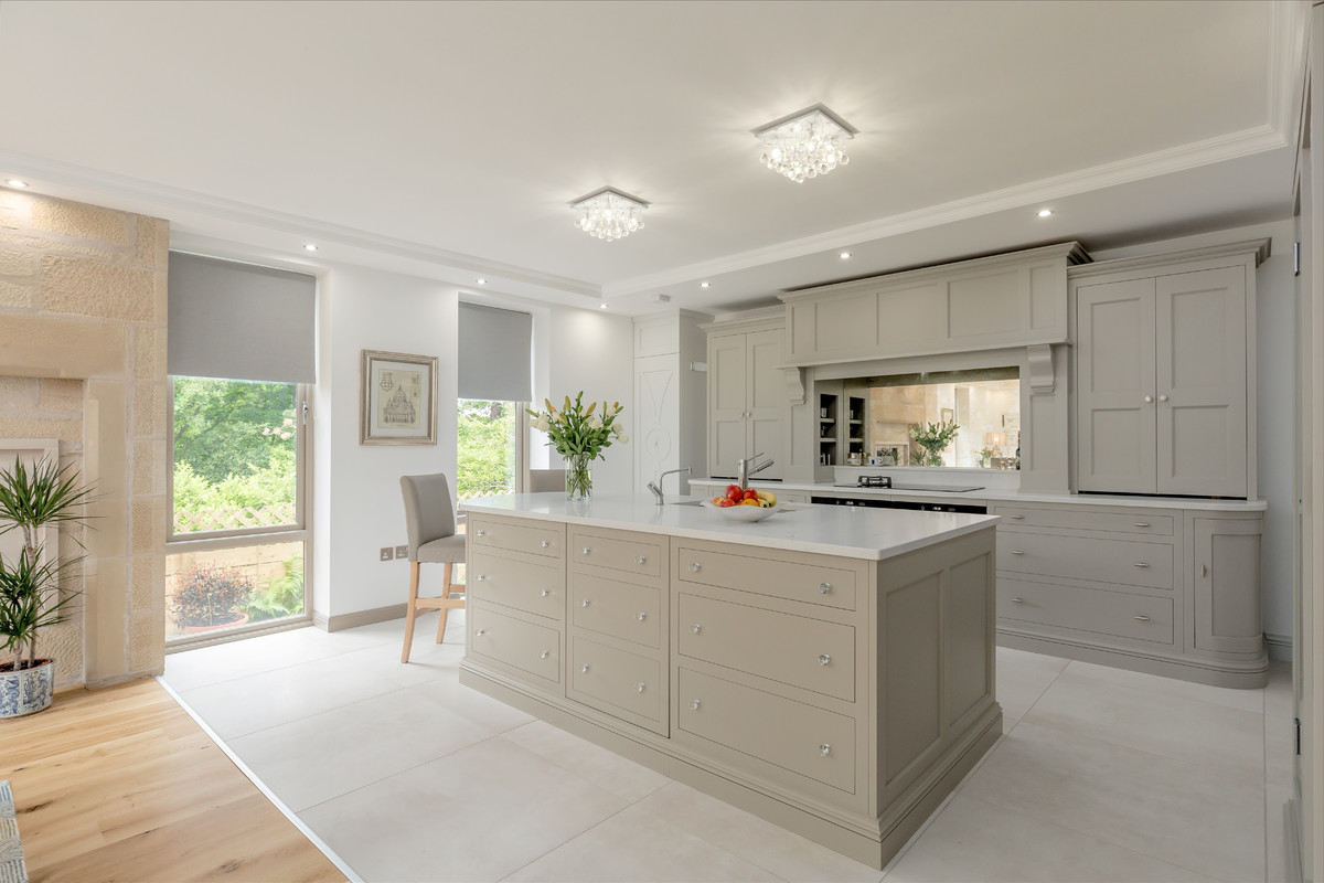 Photo of a large transitional open plan kitchen in Edinburgh with an undermount sink, flat-panel cabinets, grey cabinets, quartz benchtops, glass sheet splashback, panelled appliances, porcelain floors, with island and white floor.