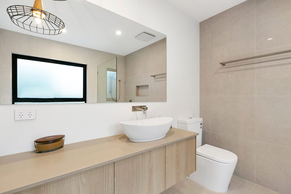 Inspiration for a mid-sized contemporary bathroom in Melbourne with light wood cabinets, a freestanding tub, an open shower, a one-piece toilet, gray tile, stone tile, grey walls, porcelain floors, engineered quartz benchtops, grey floor, an open shower and grey benchtops.