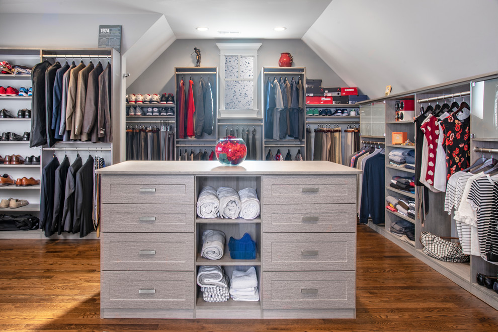 This is an example of a large transitional gender-neutral walk-in wardrobe in Chicago with shaker cabinets, grey cabinets, medium hardwood floors and brown floor.
