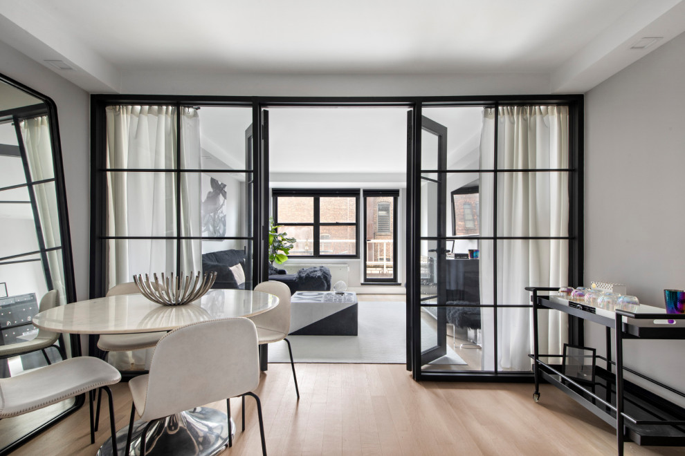 На фото: двухуровневая гостиная комната среднего размера в стиле модернизм с серыми стенами и светлым паркетным полом с