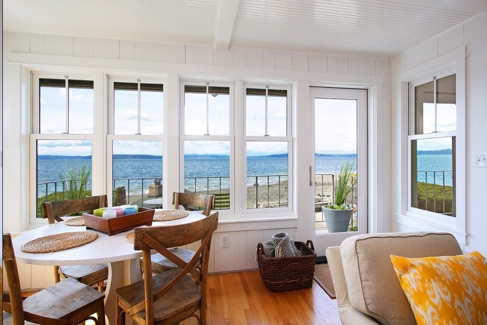 Beach style dining room in Seattle with white walls and medium hardwood floors.