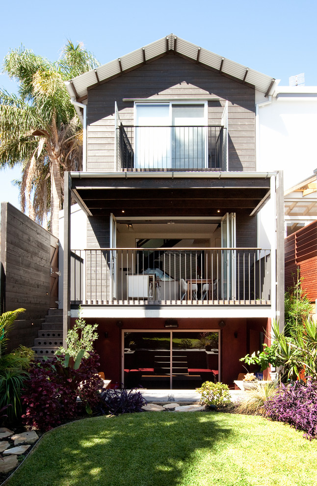 Design ideas for a beach style three-storey brown exterior in Sydney with wood siding and a gable roof.