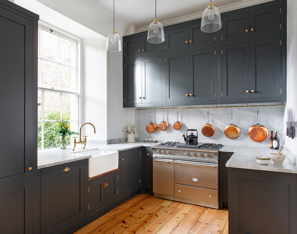Country u-shaped separate kitchen in Edinburgh with a farmhouse sink, shaker cabinets, grey cabinets, white splashback, stainless steel appliances, medium hardwood floors and no island.