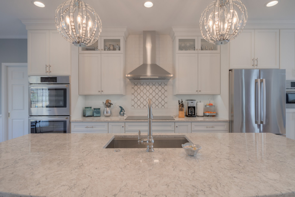 Eat-in kitchen - mid-sized transitional galley medium tone wood floor eat-in kitchen idea with an undermount sink, flat-panel cabinets, white cabinets, quartz countertops, white backsplash, subway tile backsplash, stainless steel appliances, an island and white countertops