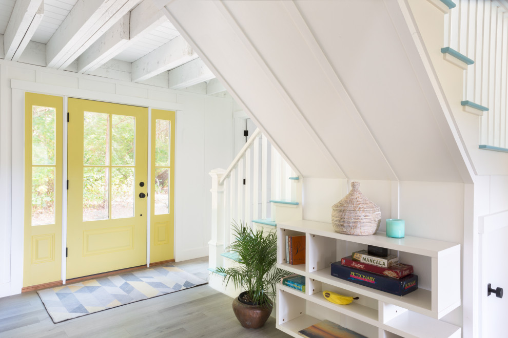 Beach style foyer in Boston with white walls, light hardwood floors, a single front door, a yellow front door, grey floor, exposed beam and panelled walls.