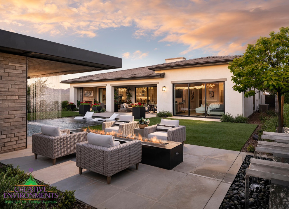 Esempio di un ampio giardino xeriscape minimalista esposto a mezz'ombra dietro casa in estate con pavimentazioni in pietra naturale e recinzione in metallo