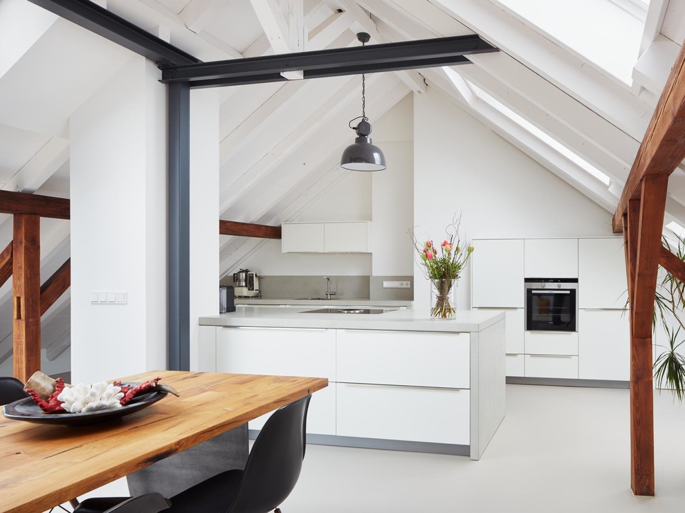 Inspiration for a contemporary galley eat-in kitchen in Berlin with flat-panel cabinets, white cabinets, black appliances, with island, a single-bowl sink, concrete benchtops, linoleum floors and grey splashback.