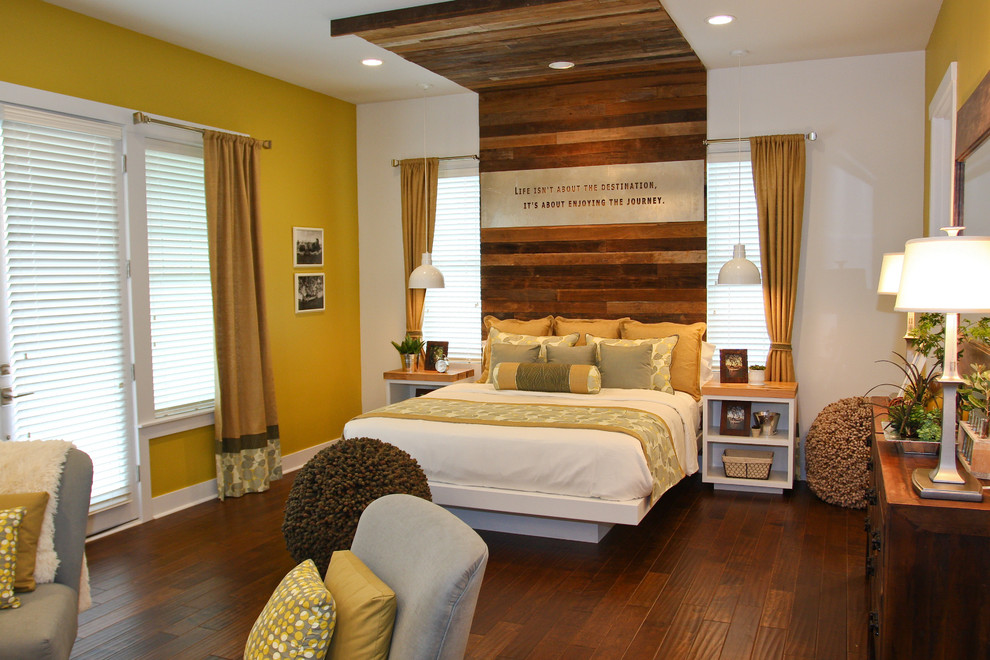 Country bedroom in Other with yellow walls and dark hardwood floors.