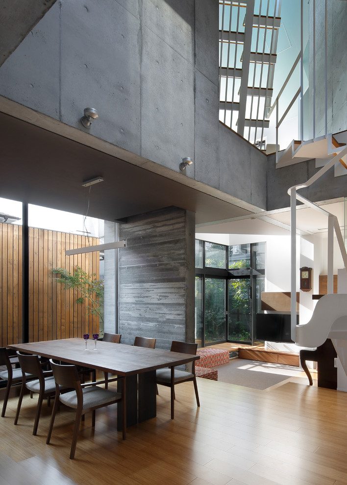 Modern family room in Tokyo with grey walls, medium hardwood floors and brown floor.