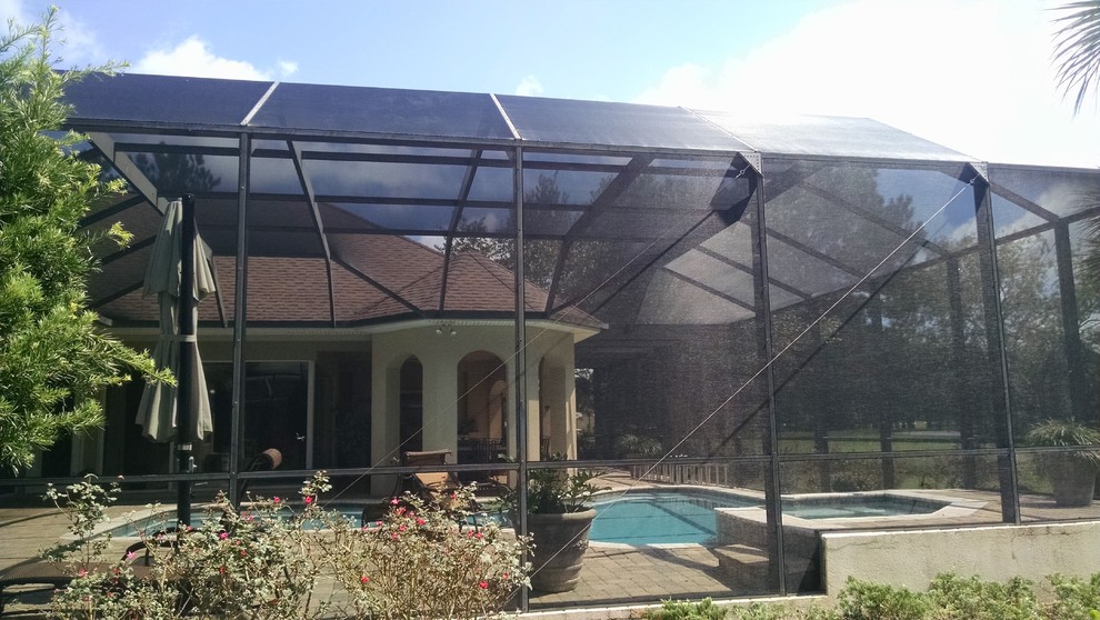Large transitional backyard stone and custom-shaped hot tub photo