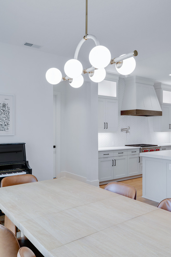 Пример оригинального дизайна: большая кухня-столовая в стиле ретро с белыми стенами, светлым паркетным полом и бежевым полом