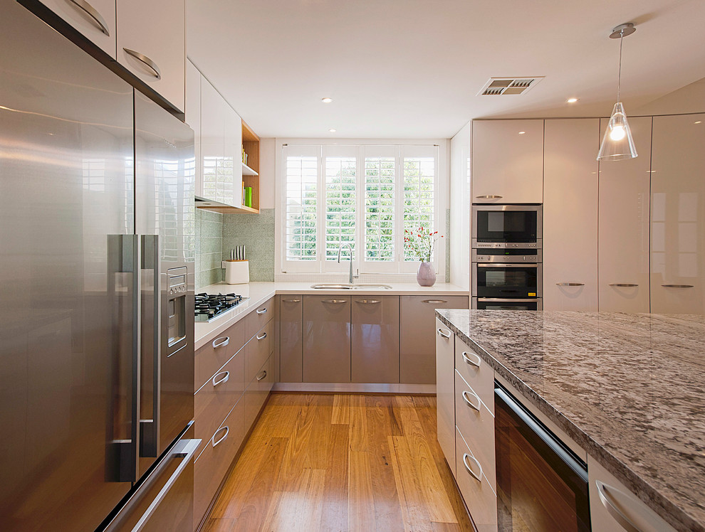 This is an example of a mid-sized contemporary l-shaped separate kitchen in Melbourne with a double-bowl sink, flat-panel cabinets, granite benchtops, green splashback, stainless steel appliances, grey cabinets, porcelain splashback, with island and medium hardwood floors.