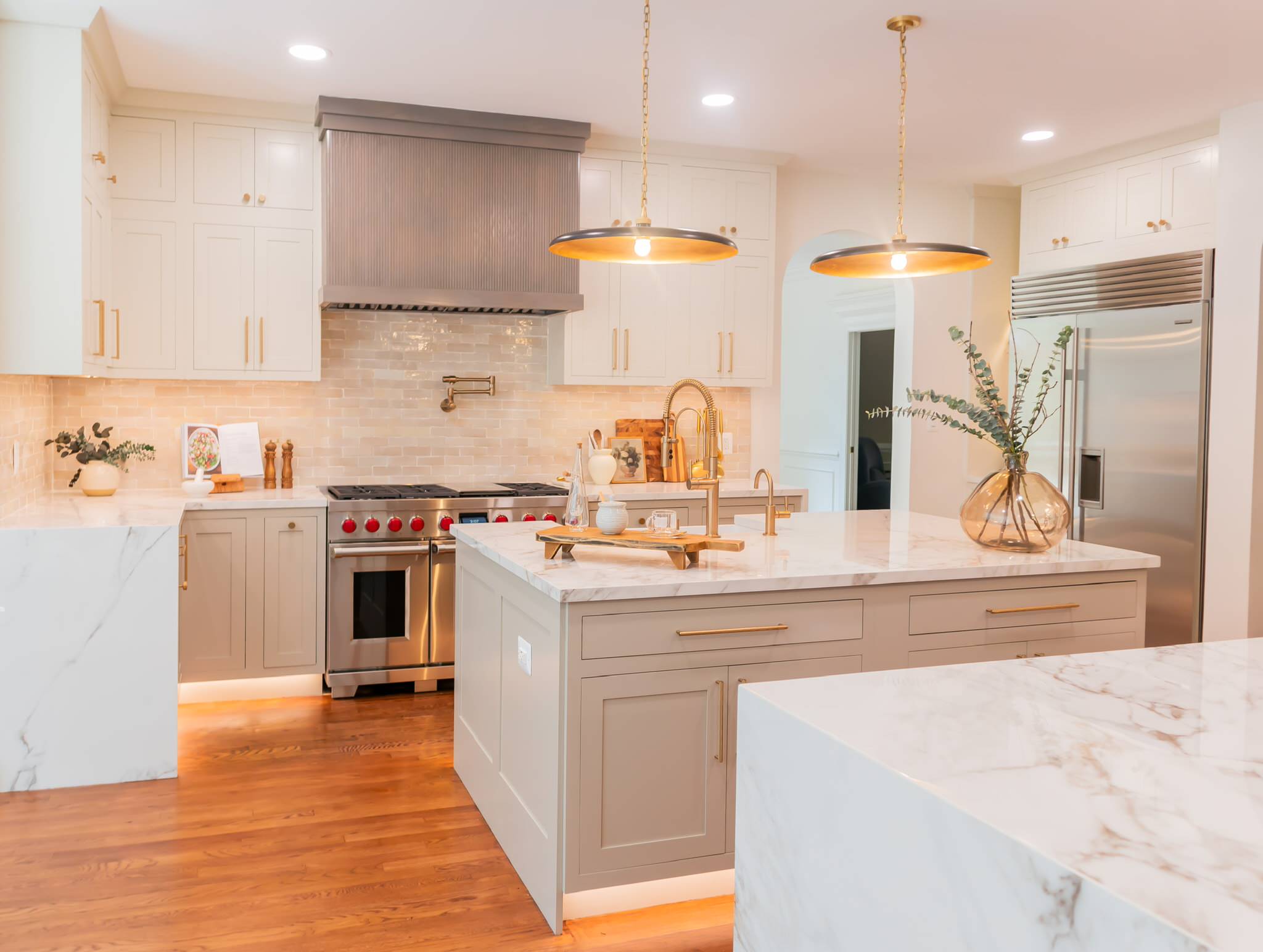 A timeless kitchen, curated with neutral tones, textures, and depth. We are completely in love with every detail from the fluted hood and peninsula, fluted fire clay sink, lux gold knurled hardware, a