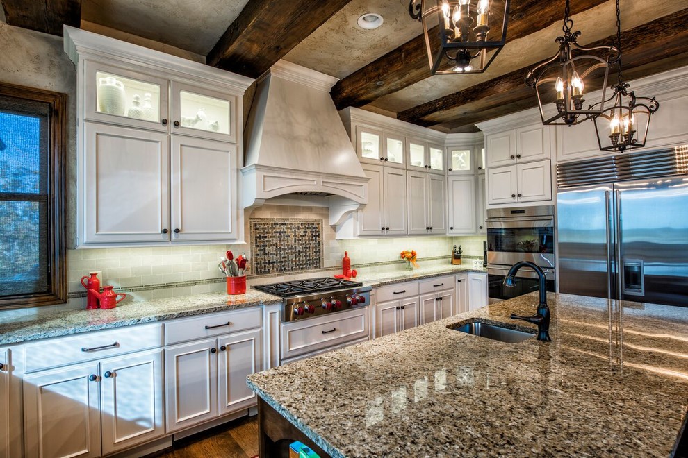 Example of a huge mountain style u-shaped dark wood floor open concept kitchen design with an undermount sink, beaded inset cabinets, white cabinets, granite countertops, white backsplash, stainless steel appliances and an island