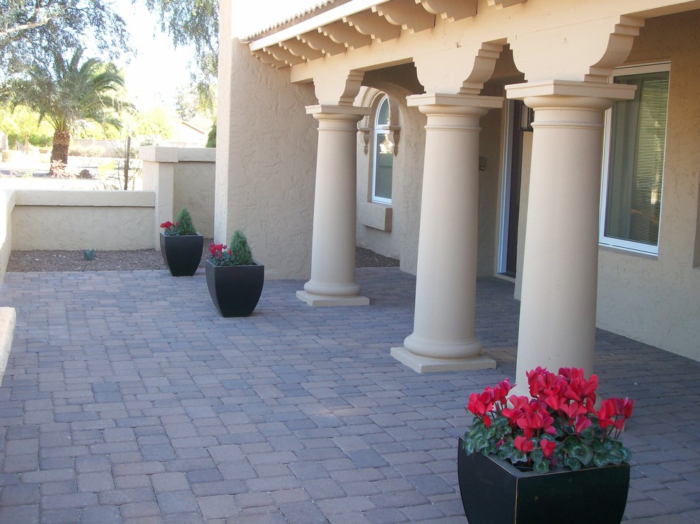 Transitional brick front porch idea in Phoenix with a roof extension