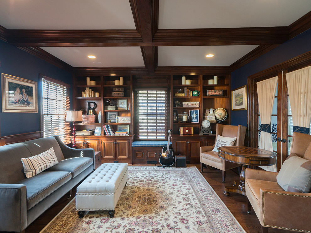 Photo of a traditional enclosed family room in New York with a library, blue walls and dark hardwood floors.