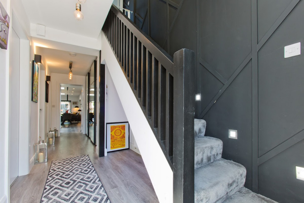 Idée de décoration pour un petit couloir design avec un mur noir, moquette et un sol gris.