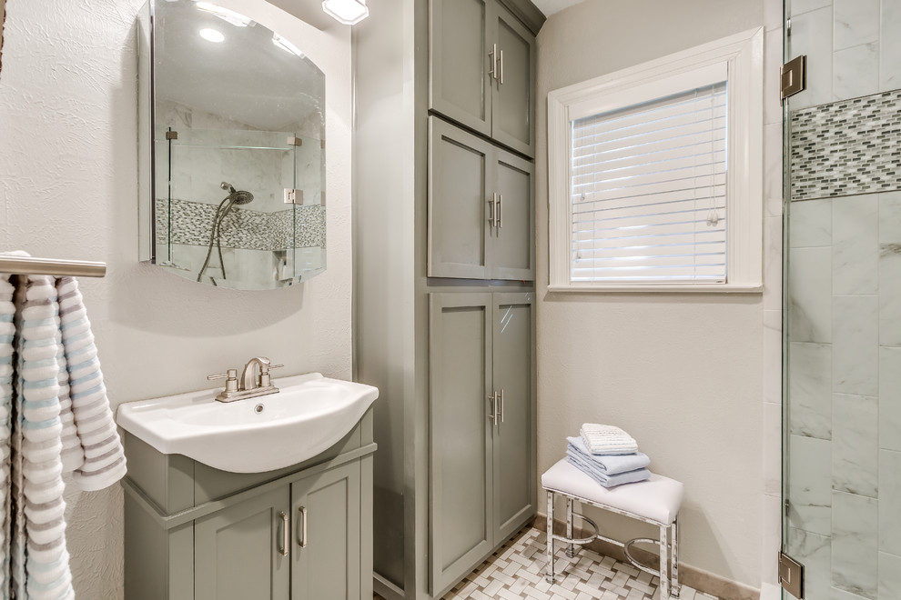 This is an example of a small traditional 3/4 bathroom in Dallas with shaker cabinets, grey cabinets, a corner shower, gray tile, multi-coloured tile, marble, grey walls, a drop-in sink and a hinged shower door.