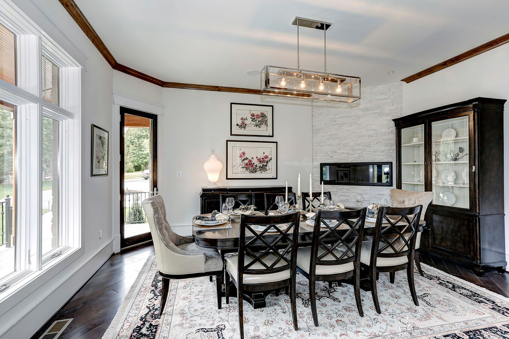 This is an example of a mid-sized transitional open plan dining in DC Metro with white walls, dark hardwood floors, a ribbon fireplace and a stone fireplace surround.