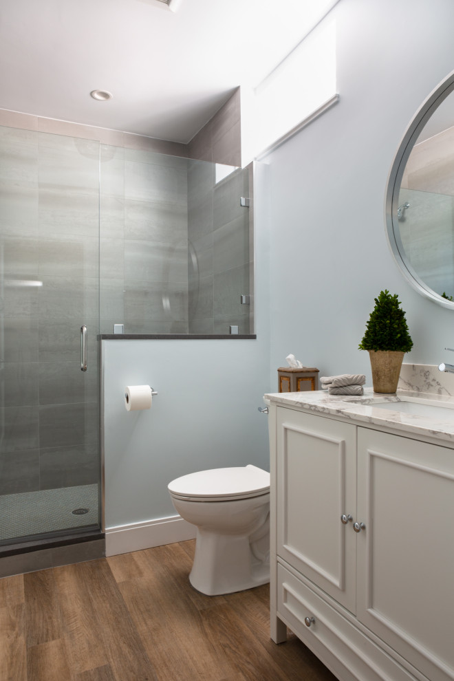 Cette photo montre une salle de bain chic de taille moyenne avec un placard en trompe-l'oeil, des portes de placard blanches, une baignoire en alcôve, WC séparés, un carrelage gris, des carreaux de porcelaine, un mur bleu, un sol en vinyl, un lavabo encastré, un plan de toilette en quartz modifié, un sol blanc, une cabine de douche à porte battante, un plan de toilette blanc, meuble double vasque et meuble-lavabo sur pied.