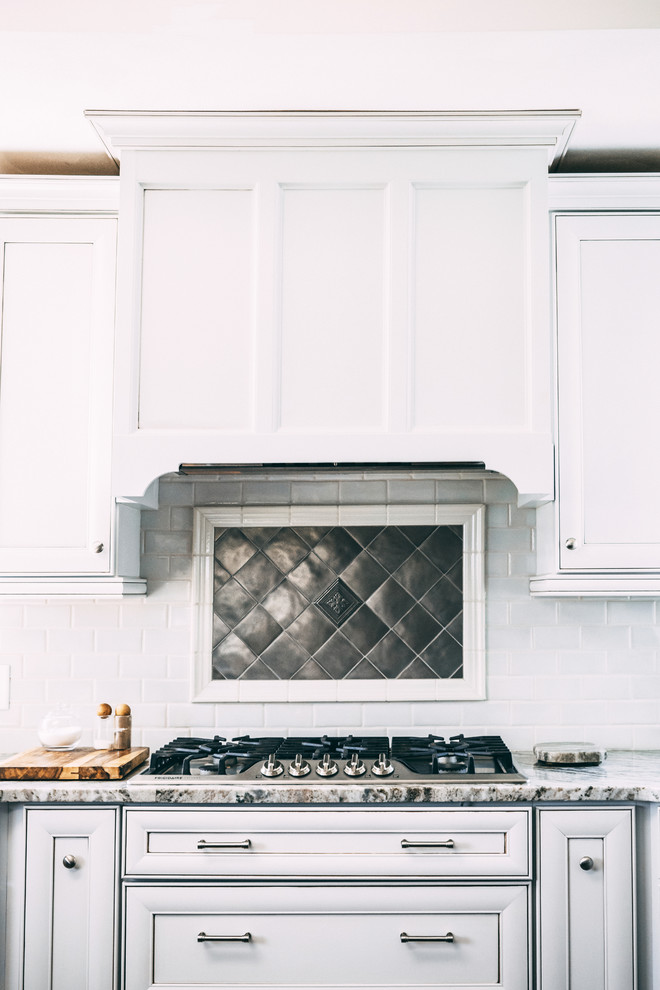 Inspiration for a transitional u-shaped brown floor and dark wood floor eat-in kitchen remodel in New York with recessed-panel cabinets, white cabinets, granite countertops, multicolored backsplash, glass tile backsplash, stainless steel appliances, an island, multicolored countertops and an undermount sink