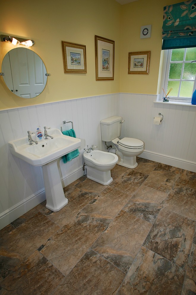 Photo of a mid-sized traditional kids bathroom in Dorset with an alcove shower, a two-piece toilet, ceramic floors, a pedestal sink and brown floor.